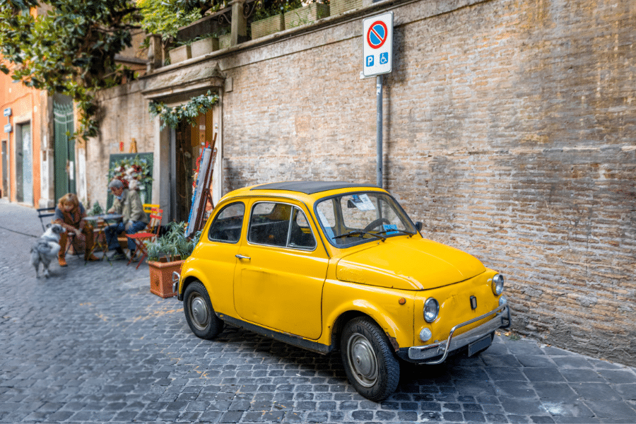 Yellow car on the street in Rome neighborhood Italy